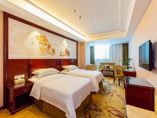 a hotel room with two beds and a television at Vienna Hotel Shenzhen Guanlan Guanguang Road Foxconn in Bao'an