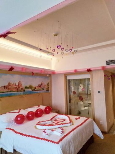 a bedroom with a bed with red decorations on it at Vienna Hotel Huizhou Dahuxi in Huizhou