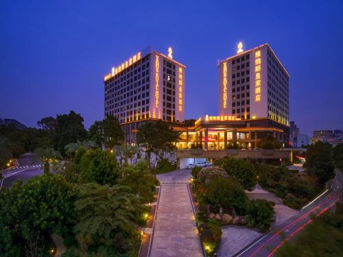 two tall buildings with lights on them at night at Vienna Hotel Shenzhen Exibition Center in Shenzhen