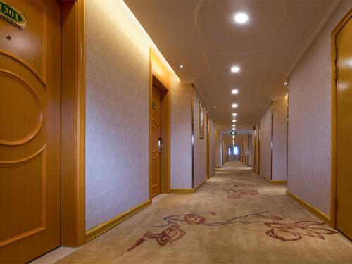 a hallway of a building with a painting on the floor at Vienna Hotel Foshan Lecong Furniture Mall in Shunde