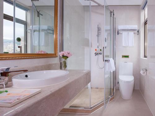 a bathroom with a sink and a glass shower at Vienna Hotel Shenzhen Longshen Subway Station in Tiantangwei