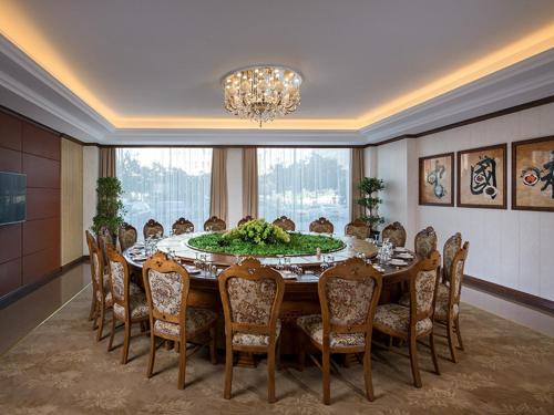 a dining room with a table and chairs and a chandelier at Vienna International Hotel Inner Mongolia Alxa League in Alxa Left