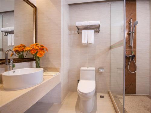 a bathroom with a toilet and a sink and a shower at Vienna Hotel Tianbao Road in Shenzhen