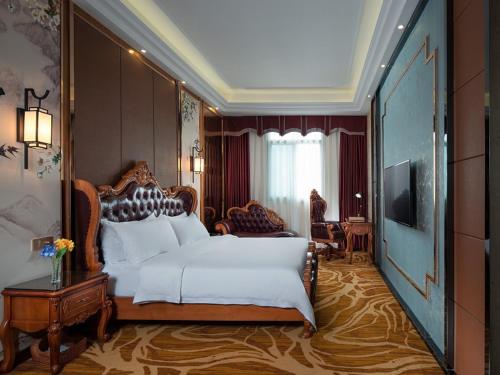 a bedroom with a large bed and a television at Vienna Hotel Shantou Chaoyang Mianxi Road in Shantou