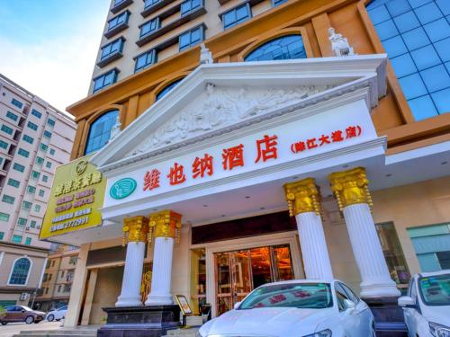 a building with a car parked in front of it at Vienna Hotel Huizhou Chenjiang Avenue in Huizhou