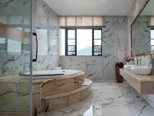 een grote badkamer met een bad en 2 wastafels bij Vienna Hotel Shantou Chaoyang Mianxi Road in Shantou