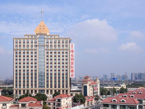 a large building with a tower on top of it at Vienna International Hotel Shanghai Hongqiao Exibition Central Xinqiao in Chunshen