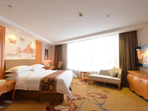 a hotel room with a large bed and a television at Vienna Hotel Shantou Chaoyang Mianxi Road in Shantou
