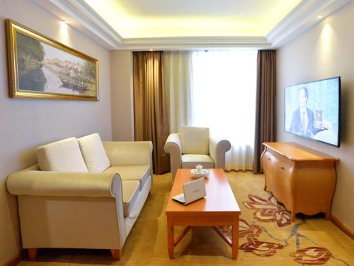 a living room with a couch and a table at Vienna Hotel Shantou Chaoyang Mianxi Road in Shantou