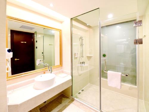 a bathroom with a sink and a glass shower at Vienna Hotel Loudi Chunyuan Pedestrian Street in Loudi
