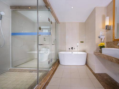 a bathroom with a shower and a tub and a sink at Vienna Hotel (Shajinbei Road Fuquan Guizhou) in Fuquan