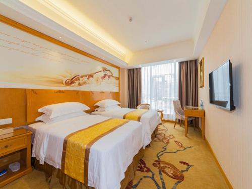 Habitación de hotel con 2 camas y TV de pantalla plana. en Vienna 3 Best Hotel Fuzhou Fuma Road Ziyang en Fuzhou