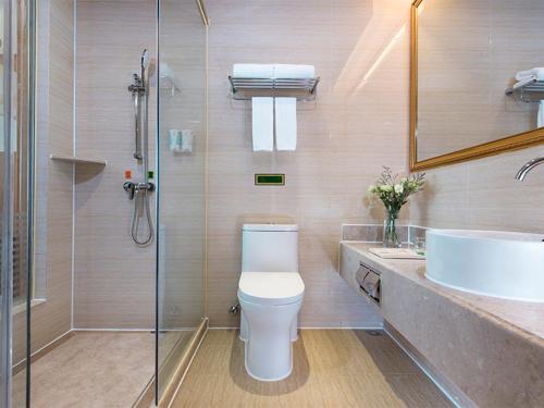 La salle de bains est pourvue de toilettes, d'un lavabo et d'une douche. dans l'établissement Vienna Hotel (Qionghai Yinhai Road), à Qionghai
