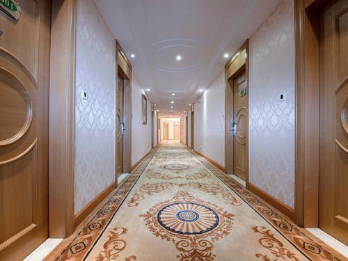 a hallway of a building with a tile floor at Vienna Hotel Dongguan Tangxia Lincun Square in Dongguan