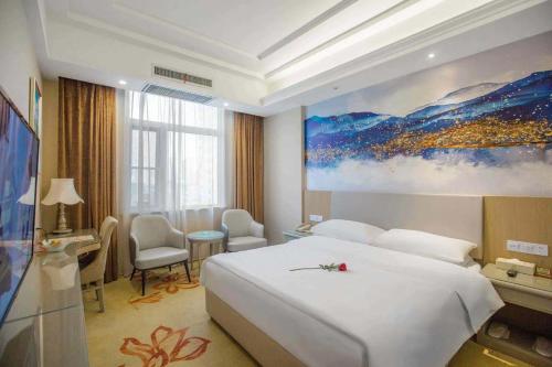 a hotel room with a bed and a painting on the wall at Vienna Hotel Nanyang People Road in Nanyang