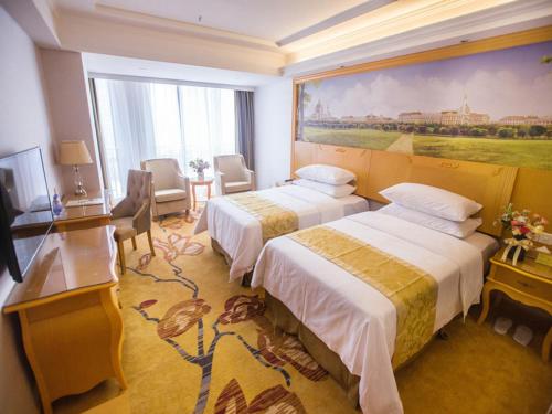 Giường trong phòng chung tại Vienna Hotel Guangdong Huizhou Jiangbei Sanxin