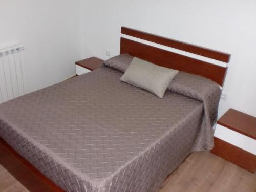 una camera da letto con un letto con testiera in legno di Casa do Canto a Macedo de Cavaleiros