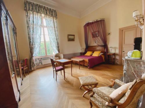 - un salon avec un lit et une table dans l'établissement B&B Chateau de Villersexel, à Villersexel