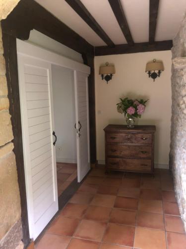 a room with a door and a dresser with a vase of flowers at Posada de Peredo y Villa in Queveda