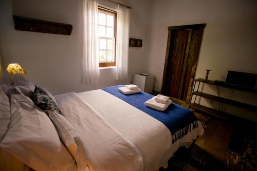 a bedroom with a bed with two towels on it at Pouso do Bichinho 1 in Bichinho