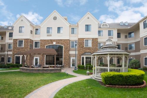 a large apartment building with a gazebo at Staybridge Suites Columbus-Airport by IHG in Columbus