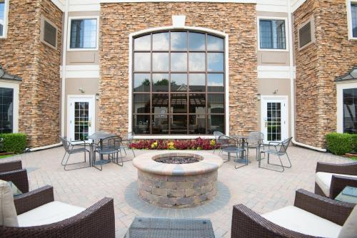a patio with chairs and a fire pit in front of a building at Staybridge Suites Columbus-Airport by IHG in Columbus