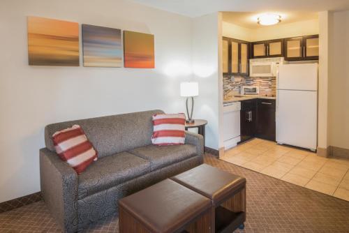 a living room with a couch and a kitchen at Staybridge Suites Columbus-Airport by IHG in Columbus
