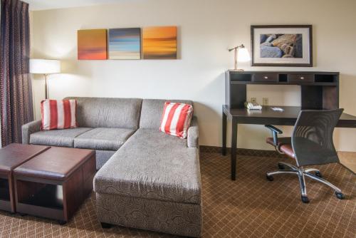 a living room with a couch and a desk at Staybridge Suites Columbus-Airport by IHG in Columbus