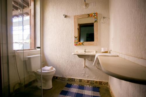 a bathroom with a toilet and a sink and a mirror at Pouso do Bichinho 1 in Bichinho