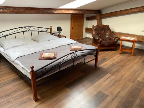 a bedroom with a bed and a leather chair at Hotel Maxim in Frýdek-Místek