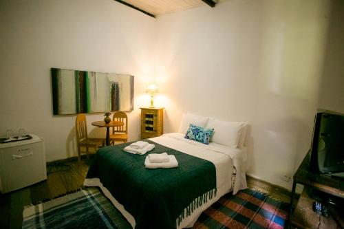 a bedroom with a bed with two towels on it at Pouso do Bichinho 1 in Bichinho