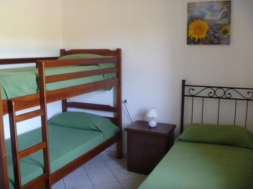 a bedroom with two bunk beds and a table with a lamp at CASADELFARO con Giardino a Pittulongu 600Metri dalla Spiaggia in Olbia