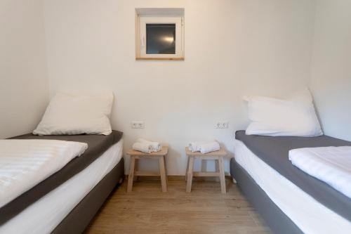 two beds in a room with two small tables at Haus Hoen in Untertweng