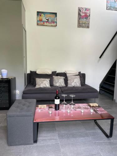 a living room with a couch and a table with wine glasses at Loft exceptionnel à Wépion avec jacuzzi extérieur l été et cabine infrarouge in Wépion