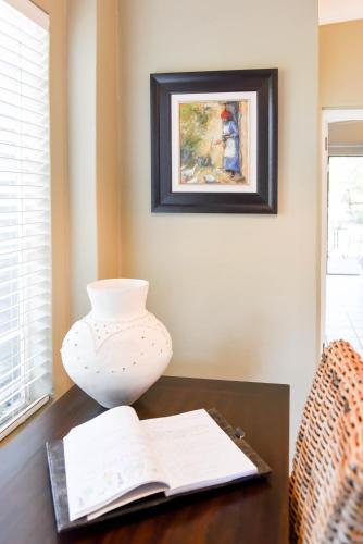 a vase sitting on top of a table with a book at Bella's B&B in Vryheid