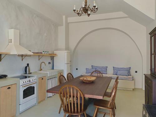 uma cozinha com uma mesa e cadeiras e uma cozinha com um sofá em 1890 Fanourakis House em Halki