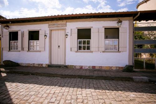 a white building with windows and a door at Pouso do Bichinho 1 in Bichinho