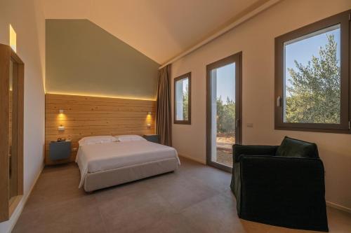 a bedroom with a bed and a couch and a window at Baglio Custera in Marsala