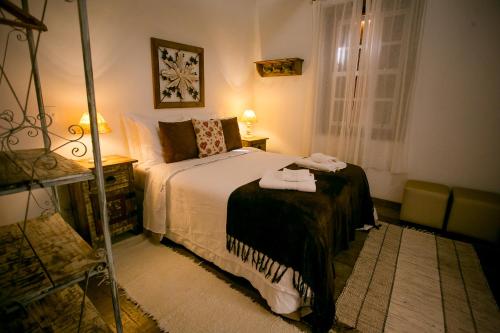 a bedroom with a bed and a table and a window at Pouso do Bichinho 1 in Bichinho