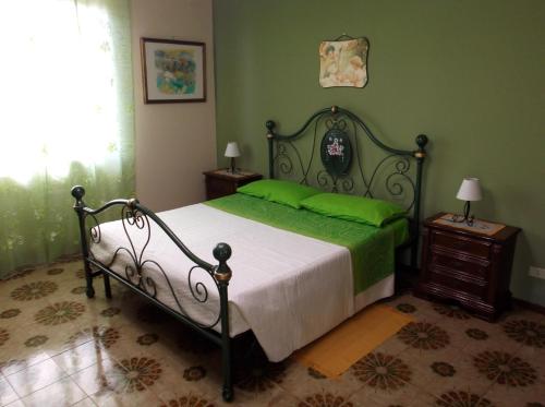 a bedroom with a bed with a green wall at La Valle dell'Etna in Zafferana Etnea