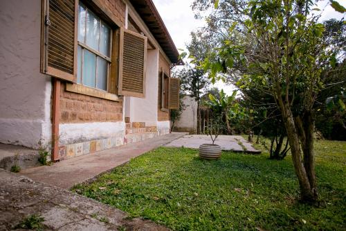a house with a tree next to a building at Pouso do Bichinho 1 in Bichinho