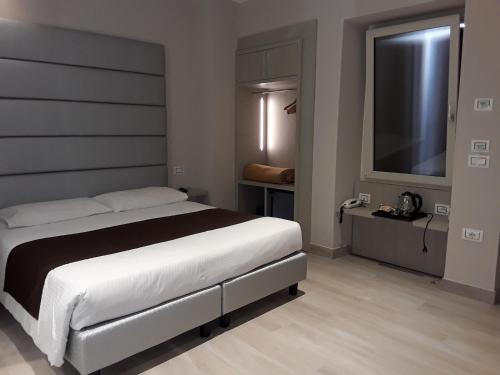 a bedroom with a bed and a flat screen tv at Hotel Danieli La Castellana lago di Garda in Brenzone sul Garda