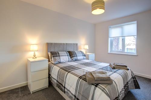 1 dormitorio con cama y ventana en Sunderland Short Stays 2 bedroom apartment Free Parking Fulwell SR6, en Sunderland