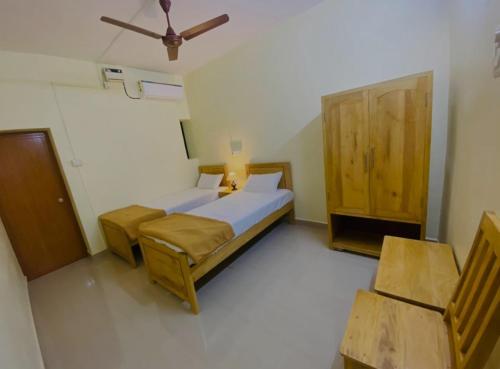 1 dormitorio con 1 cama y armario de madera en Thyme Guest House, en Palolem