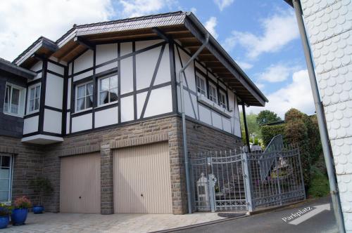a black and white house with a garage at Wohnen im bergischen Fachwerk in Overath