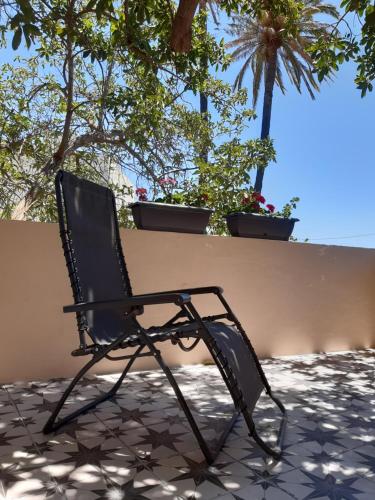 a black chair sitting in front of a wall at Villa Nestor in Ingenio