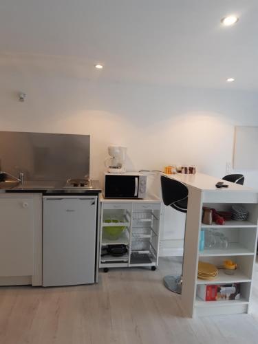 a kitchen with a white counter and a table at Un coin en Provence in Villeneuve