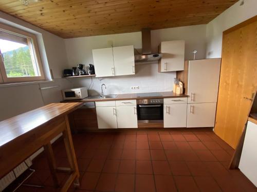 a kitchen with white cabinets and a wooden counter top at Ferienwohnung Grabner in Hermagor