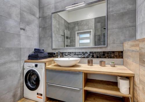 un bagno con lavandino e lavatrice di Apartamenty Teatralna Świnoujście a Świnoujście
