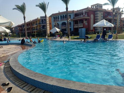 a pool at a resort with people in it at شاليهات بورتو مطروح فيو بحر Porto Matrouh Sea View Families Only in Marsa Matruh